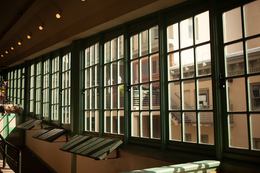 a green bench sitting in front of a window