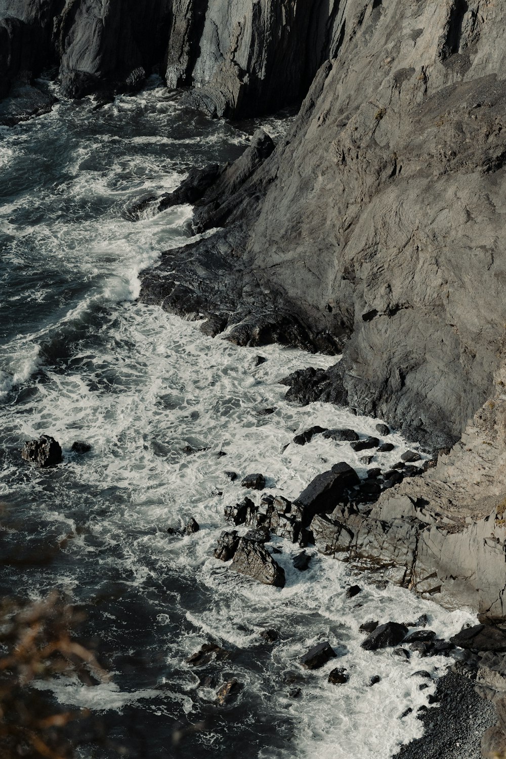 a person sitting on a rock near the ocean