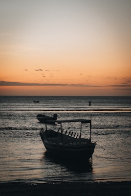 A serene sailboat anchored near a quiet cove at sunset, inviting peaceful connection.
