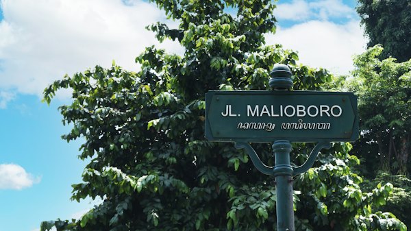 A street sign in front of some trees — Yogyakarta, Indonesia