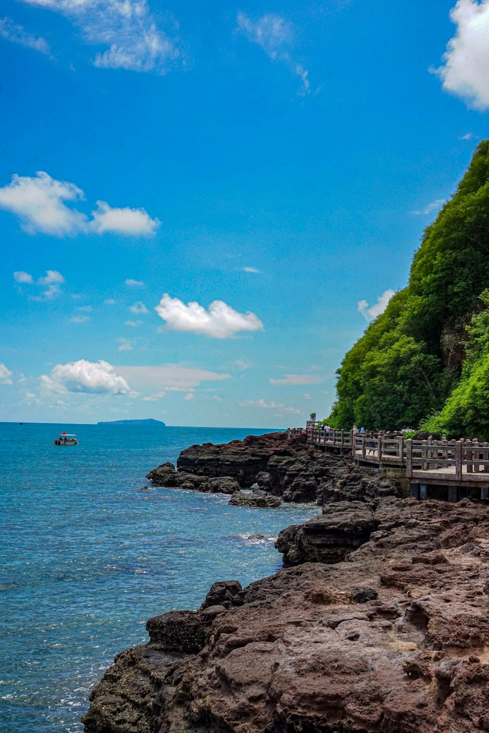 a boat is on the water near a rocky shore