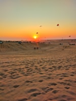 A vibrant desert safari sunset with travelers enjoying the view.