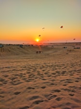 A vibrant sunset over the Dubai desert with a group of tourists on a safari jeep.