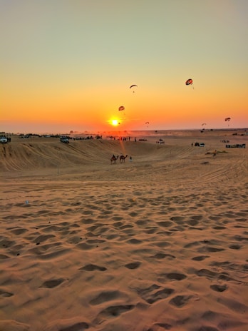 A vibrant sunset over the Dubai desert with a group of tourists on a safari jeep.