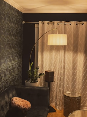 A stylish living room corner featuring a soft floor pillow and a blackout room divider curtain.