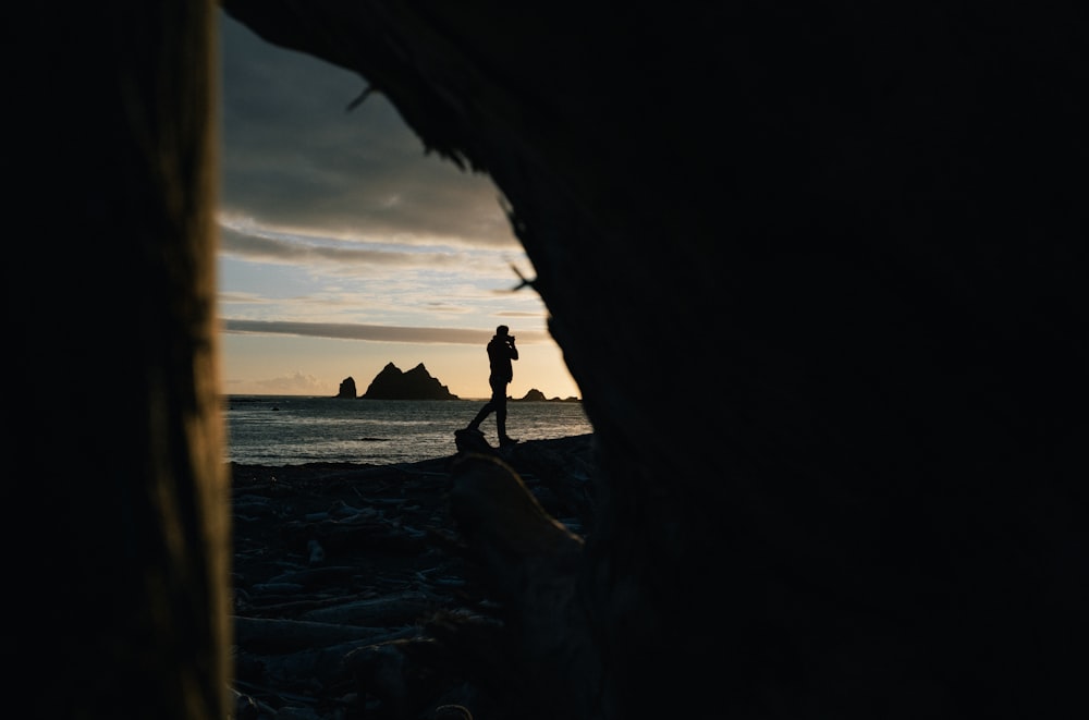 Una persona in piedi su una roccia vicino all'oceano
