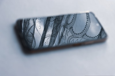 Close-up of a poetic design element inspired by traditional Indian motifs on a smartphone screen.