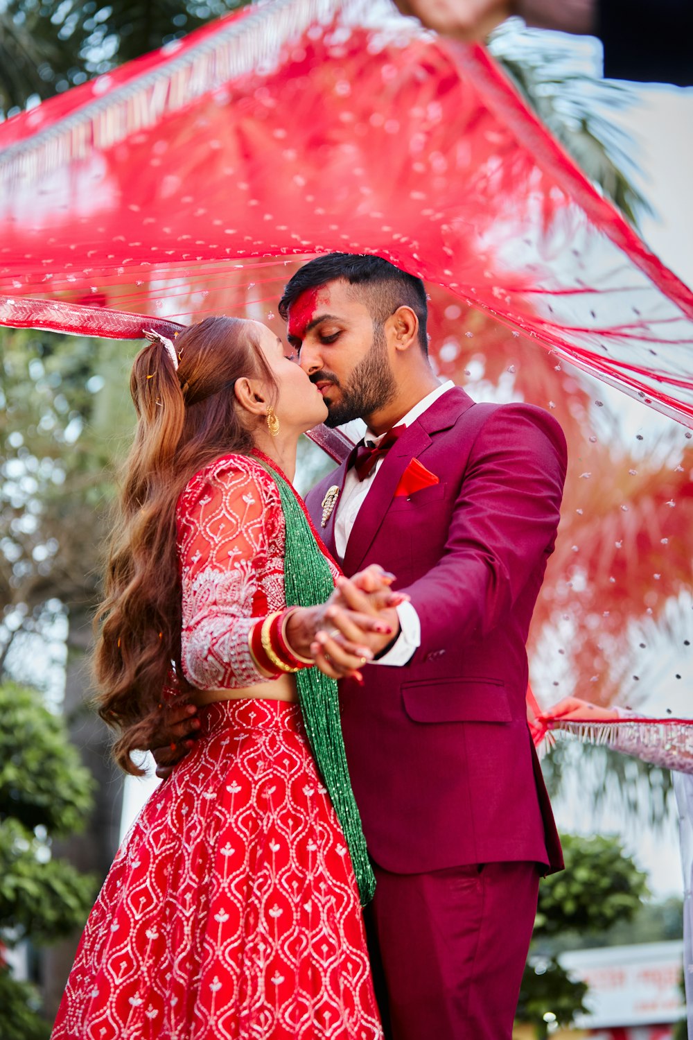 a man and woman kissing under an umbrella