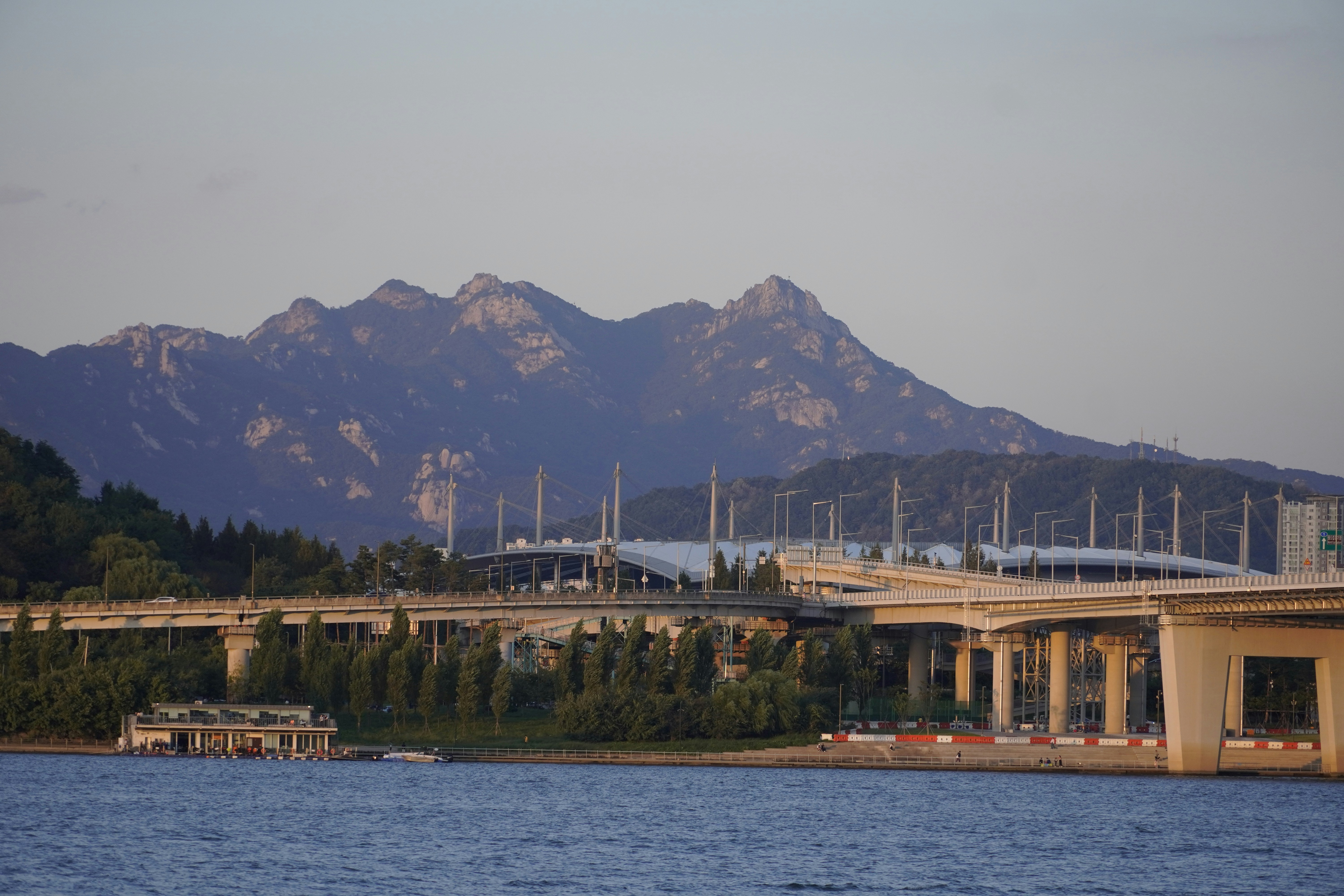 a bridge over a body of water with mountains in the background