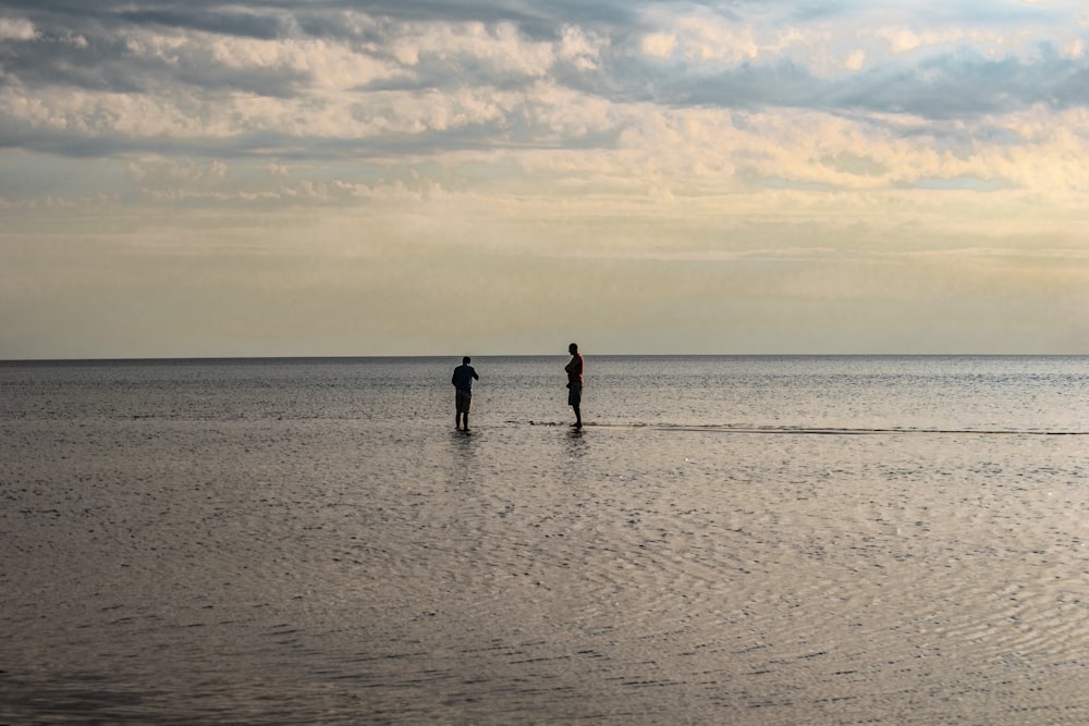 a couple of people standing on top of a large body of water