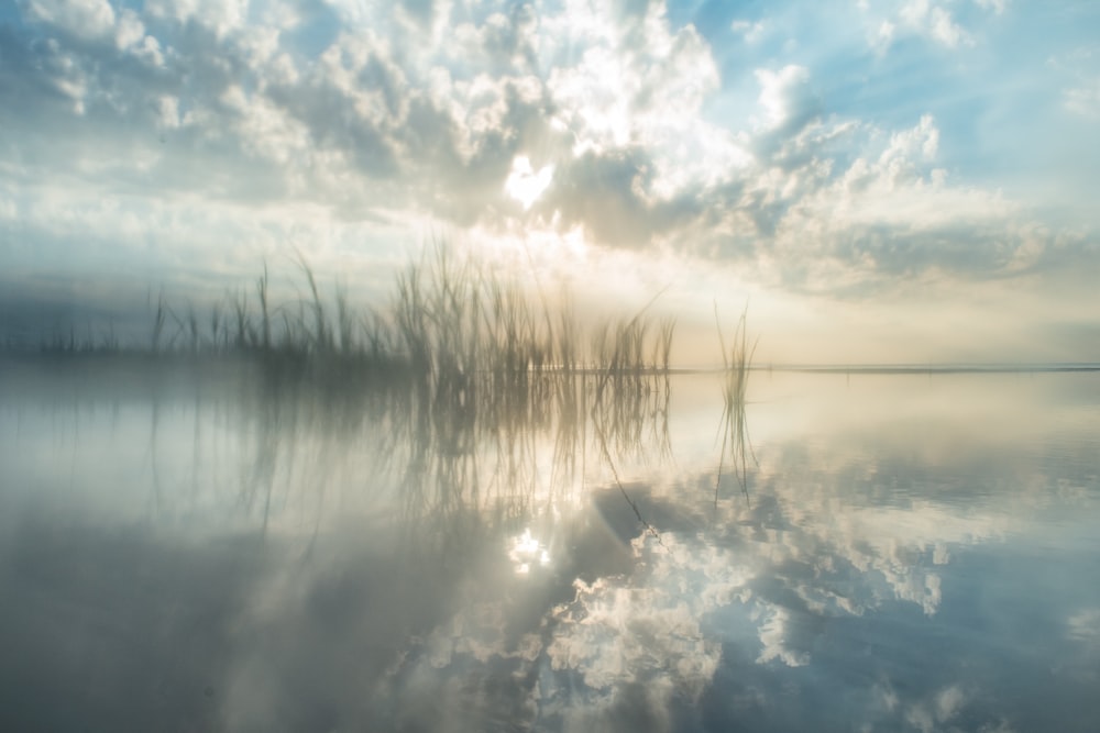 the sun is shining through the clouds over the water