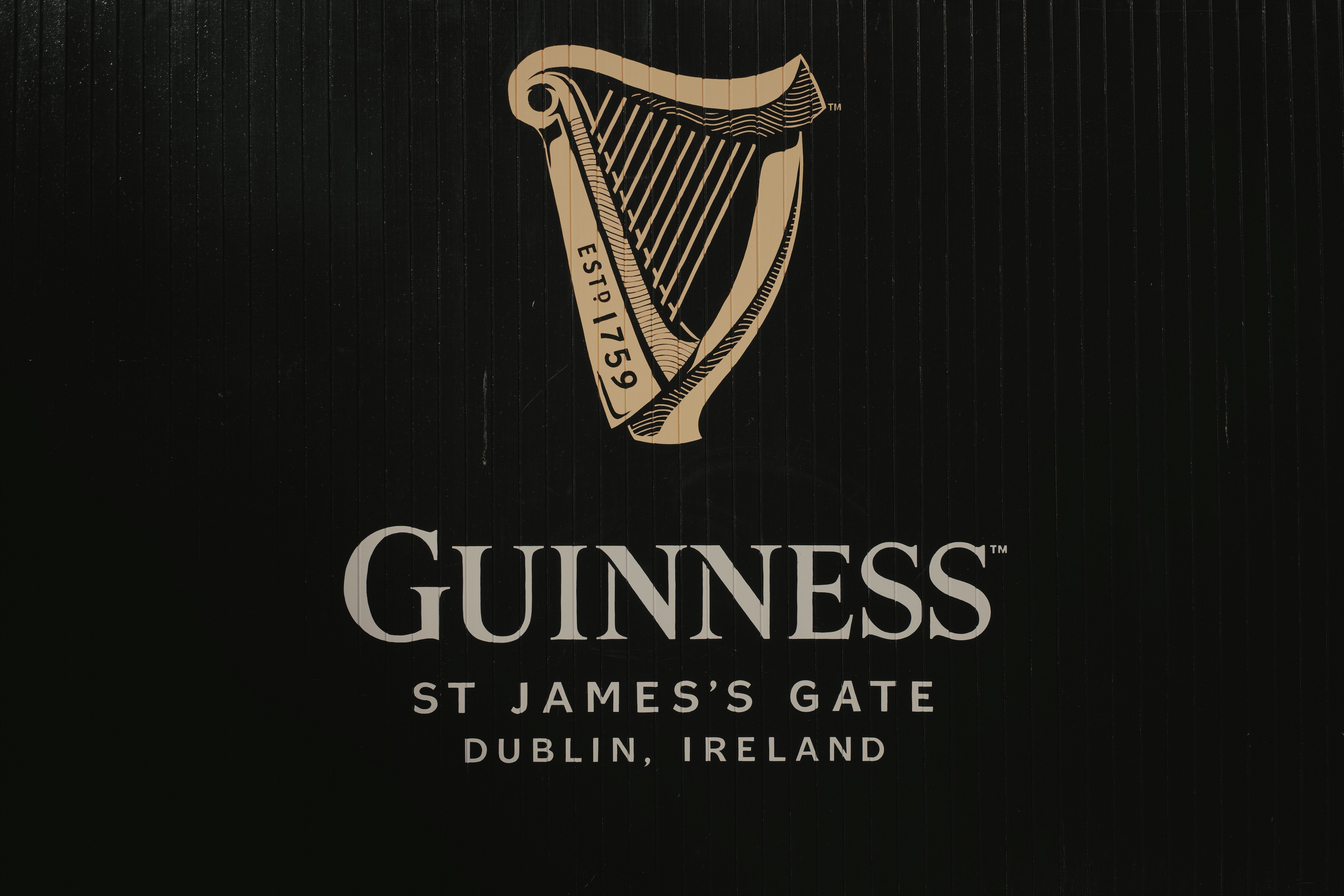 The guinness logo on the side of a building photo – Free Musical