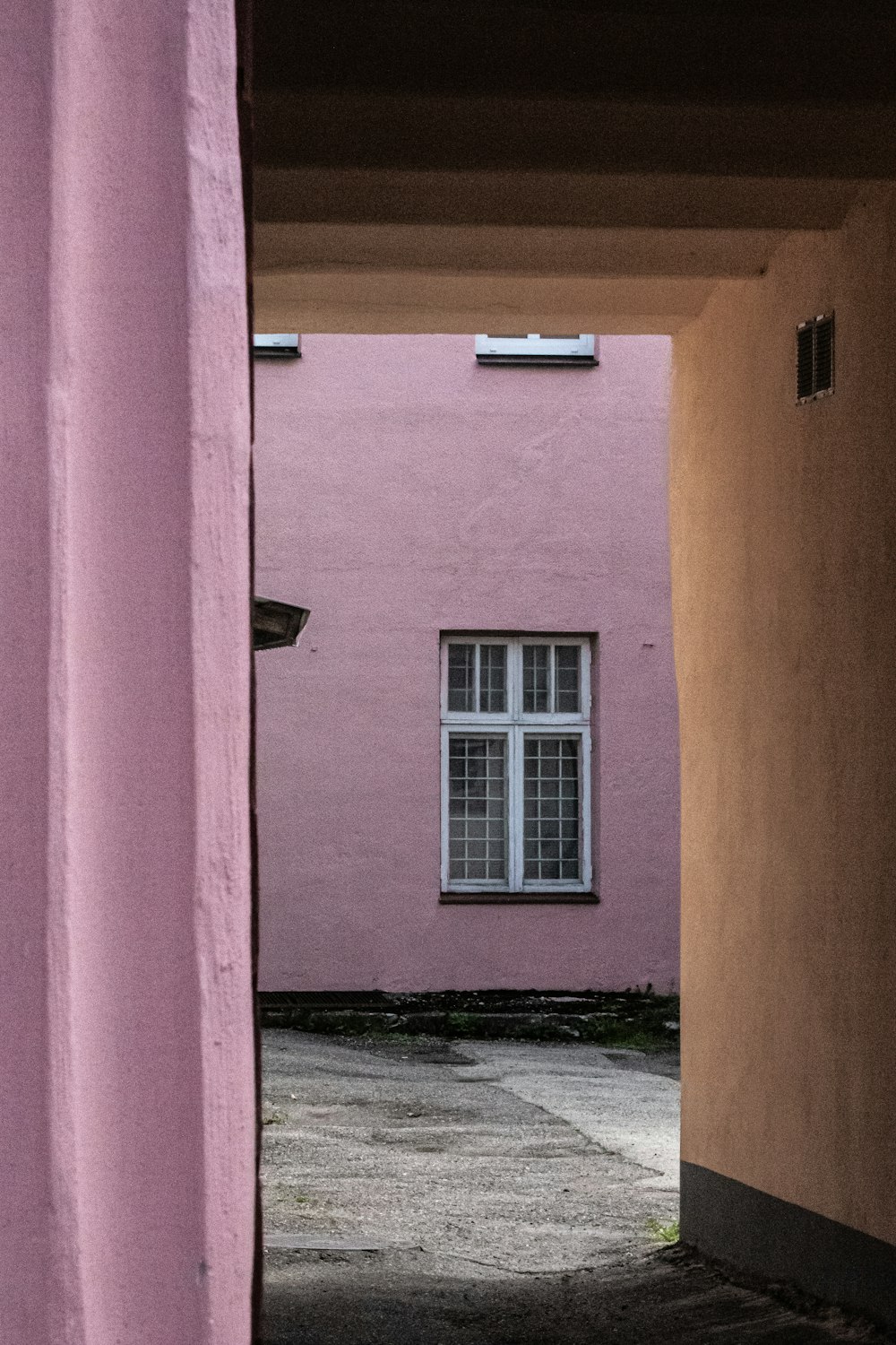 a pink building with a white window in the middle of it