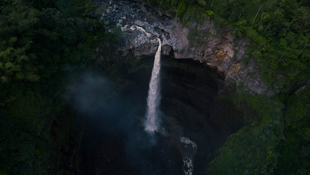 an aerial view of a waterfall in the jungle