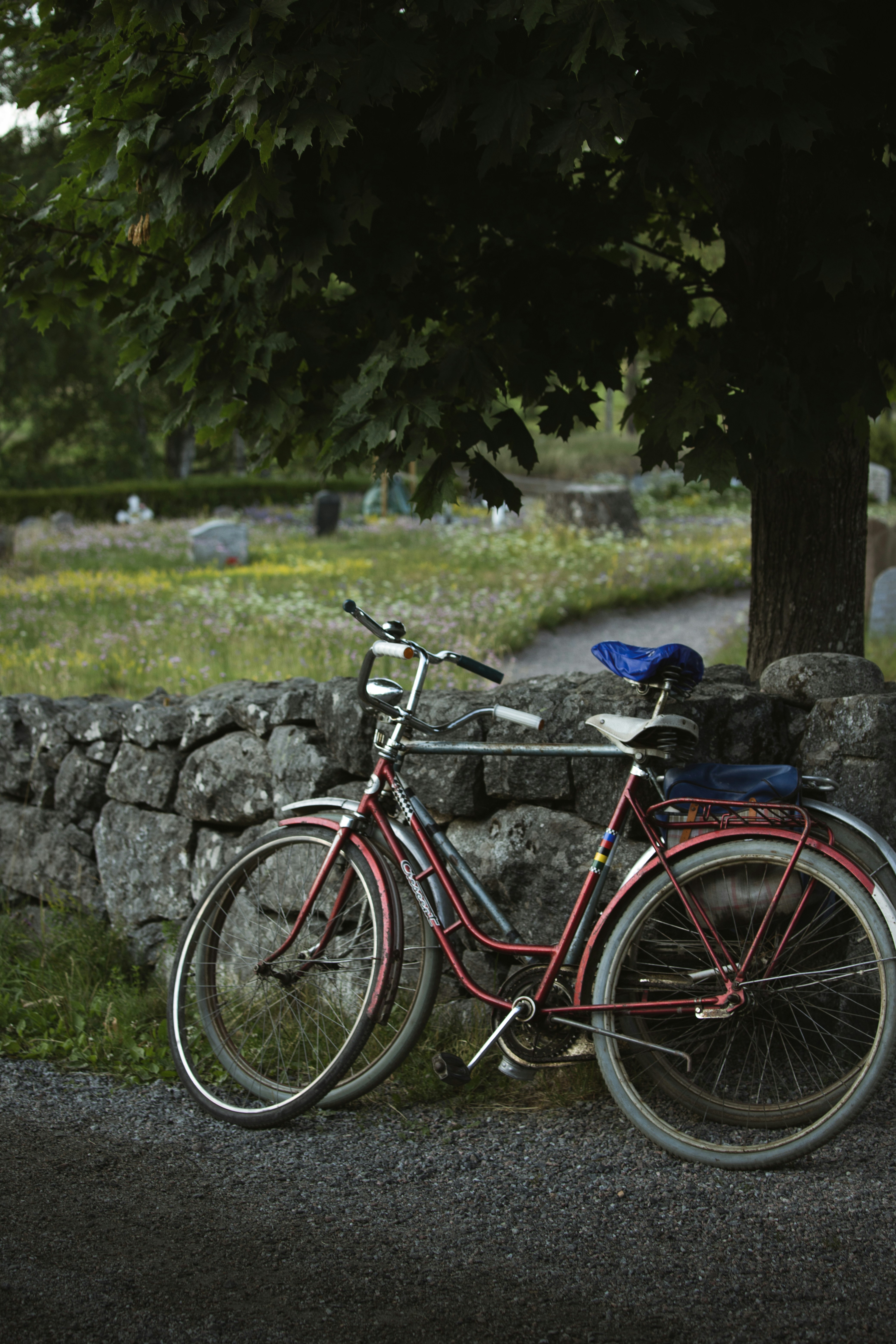 a red bicycle parked next to a stone wall