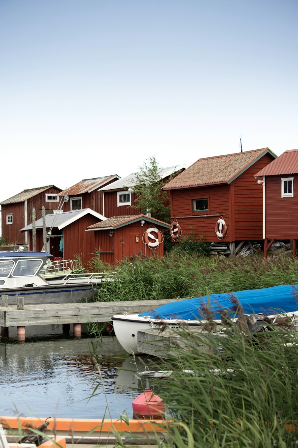 a row of red houses next to a body of water