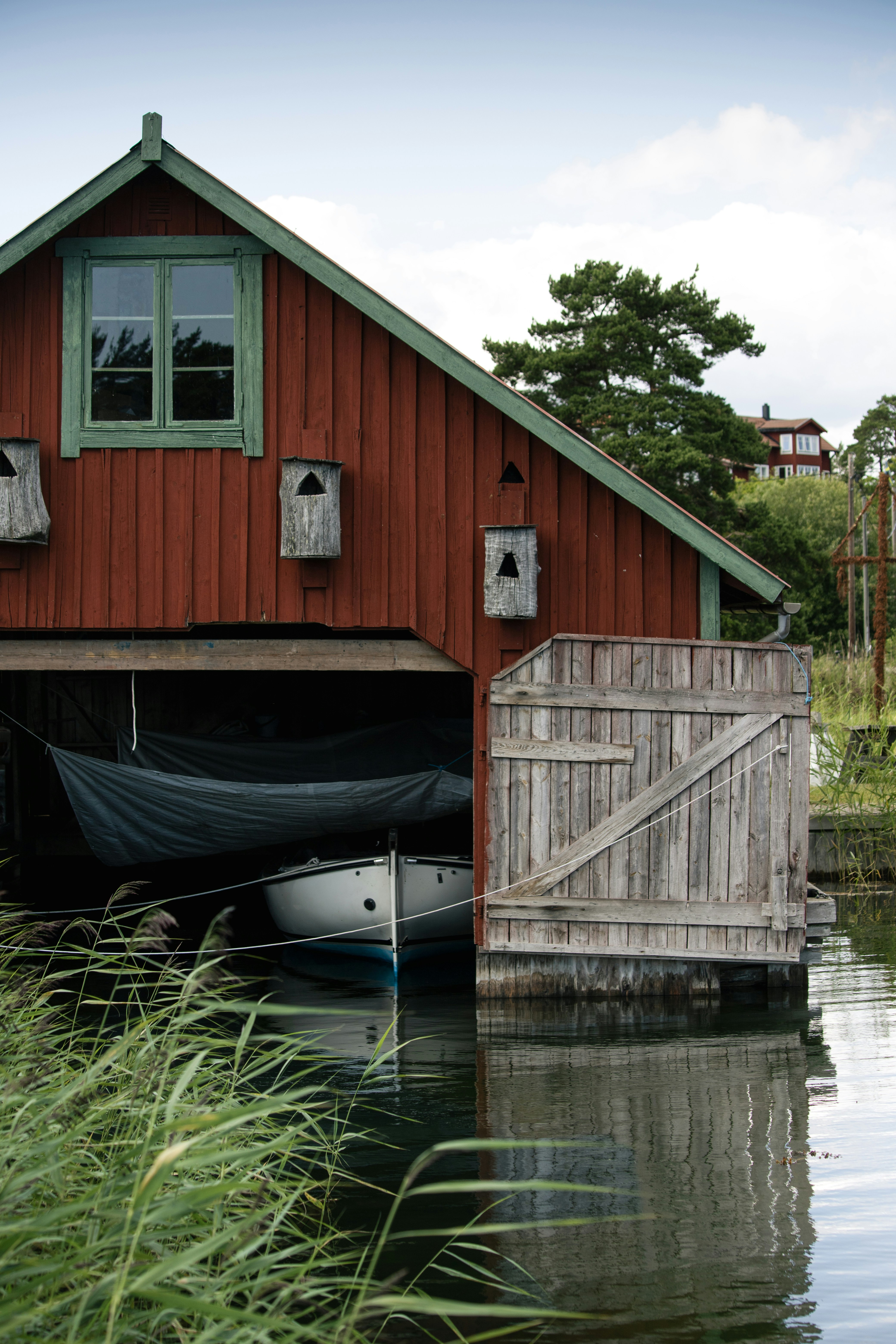 a boat sits in the water in front of a red building