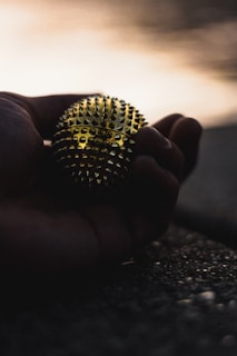 Close-up of hands gently holding a Pilates ball, symbolizing care and balance.