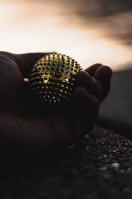 Close-up of hands holding a stress relief ball with a peaceful background.