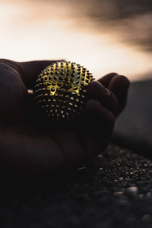Close-up of hands gently holding a Pilates ball, symbolizing care and balance.