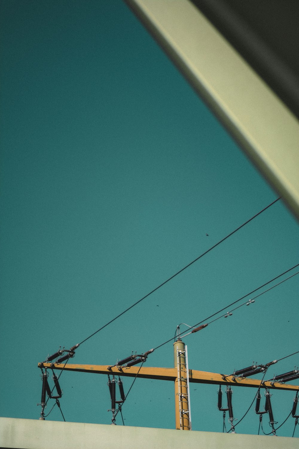 an overhead view of power lines and wires against a blue sky