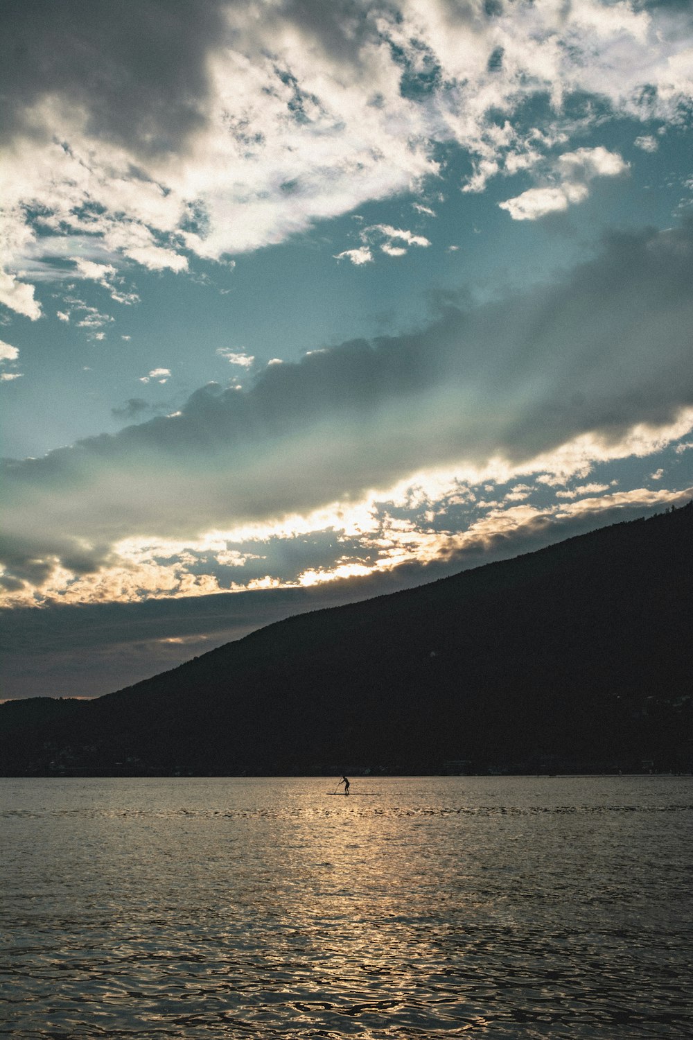 a boat is out on the water under a cloudy sky