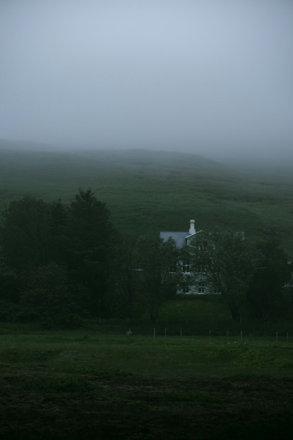 a house in the middle of a foggy field