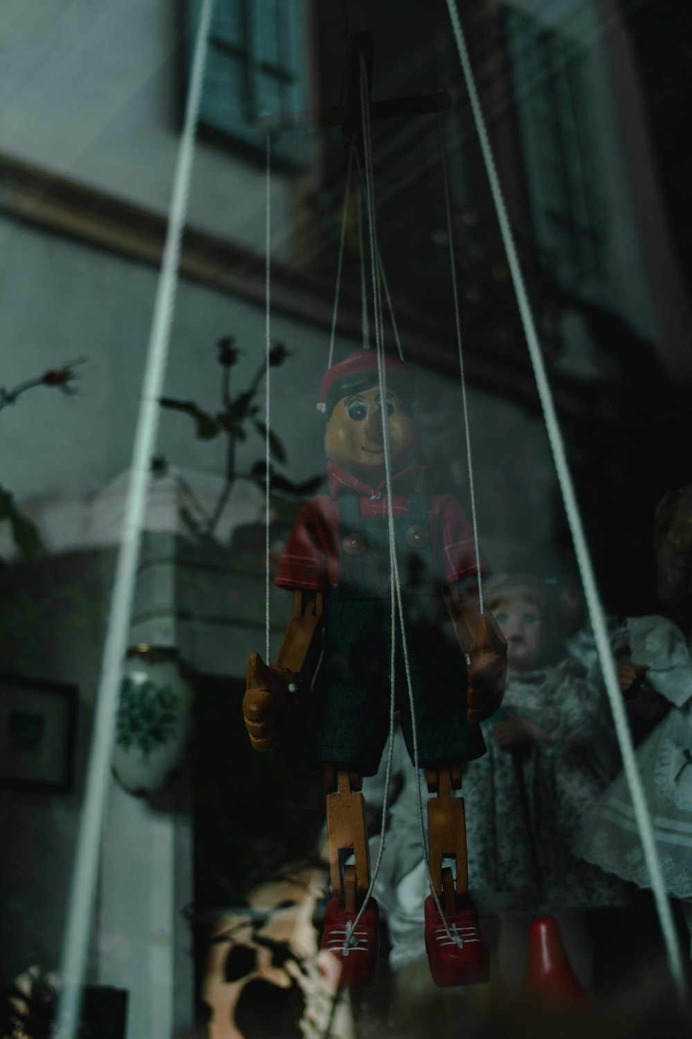 a doll hanging from a string in a window
