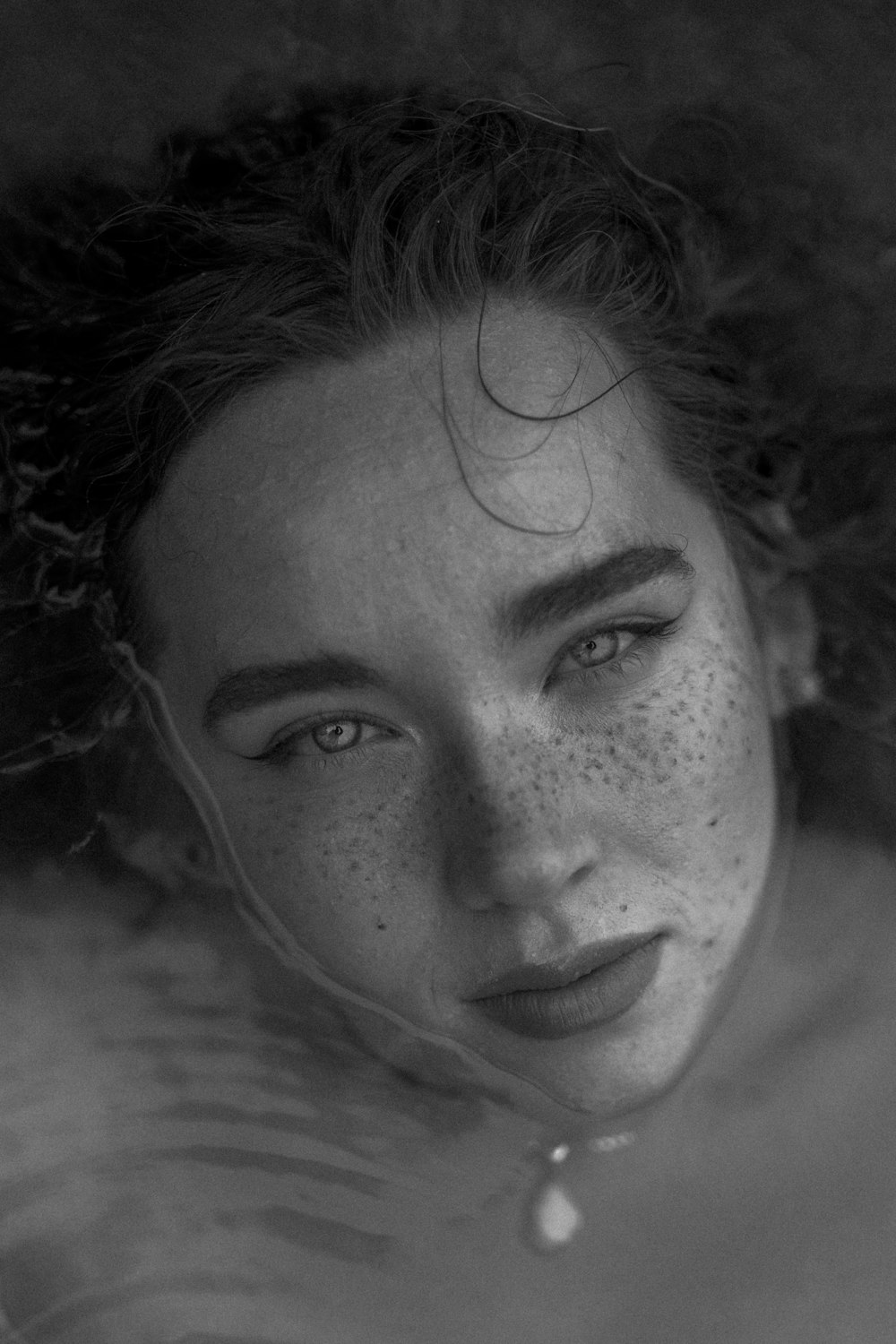 a black and white photo of a woman with freckled hair