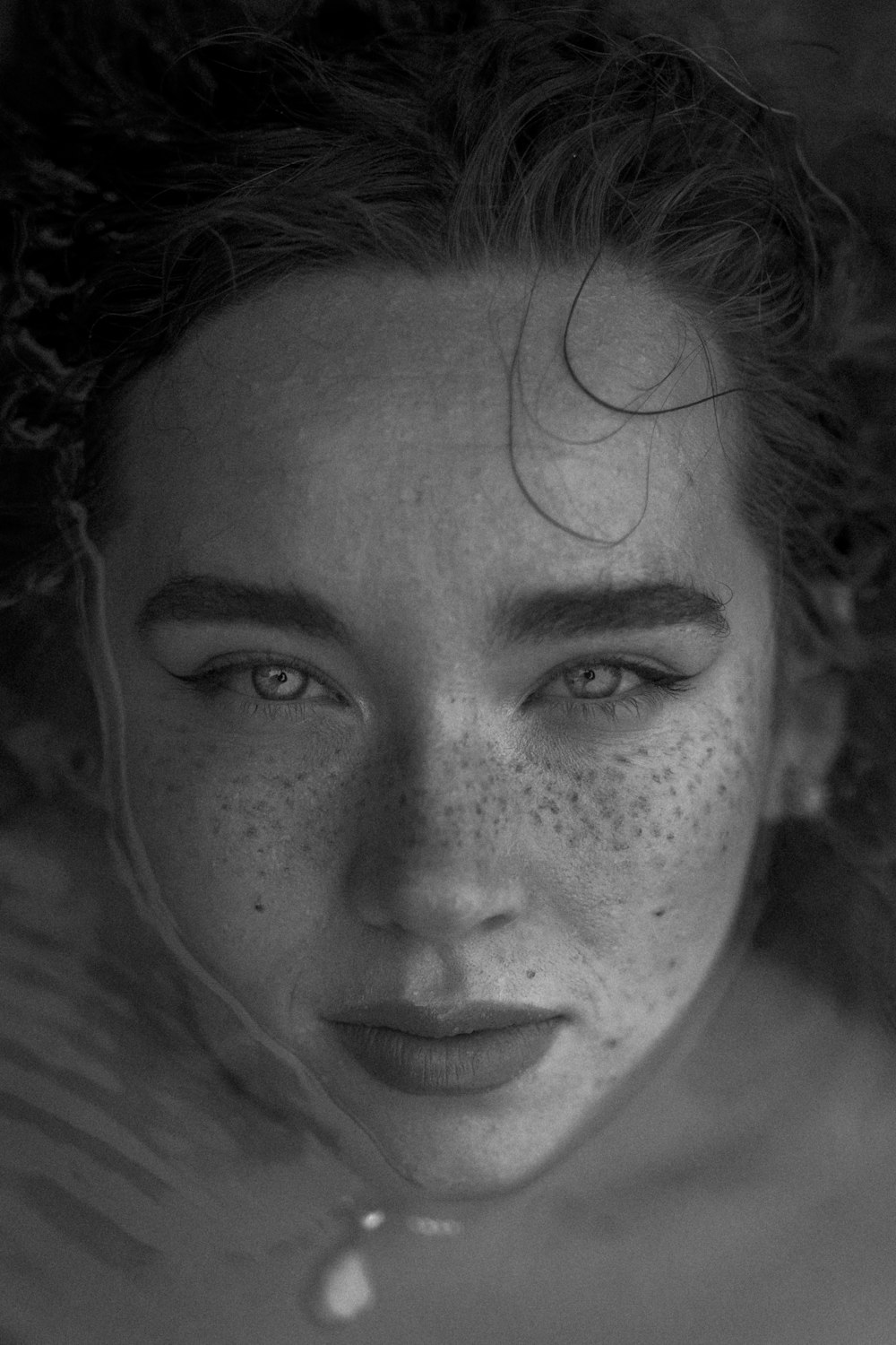 a black and white photo of a woman with freckled hair