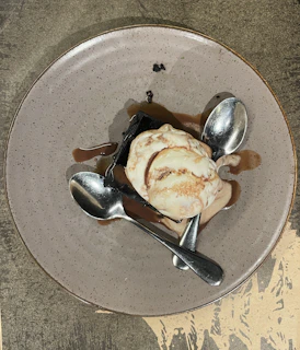 A tempting dessert plate showcasing a rich chocolate brownie topped with vanilla ice cream