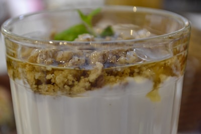 A close-up of a dessert bowl topped with fresh fruit and a drizzle of honey.
