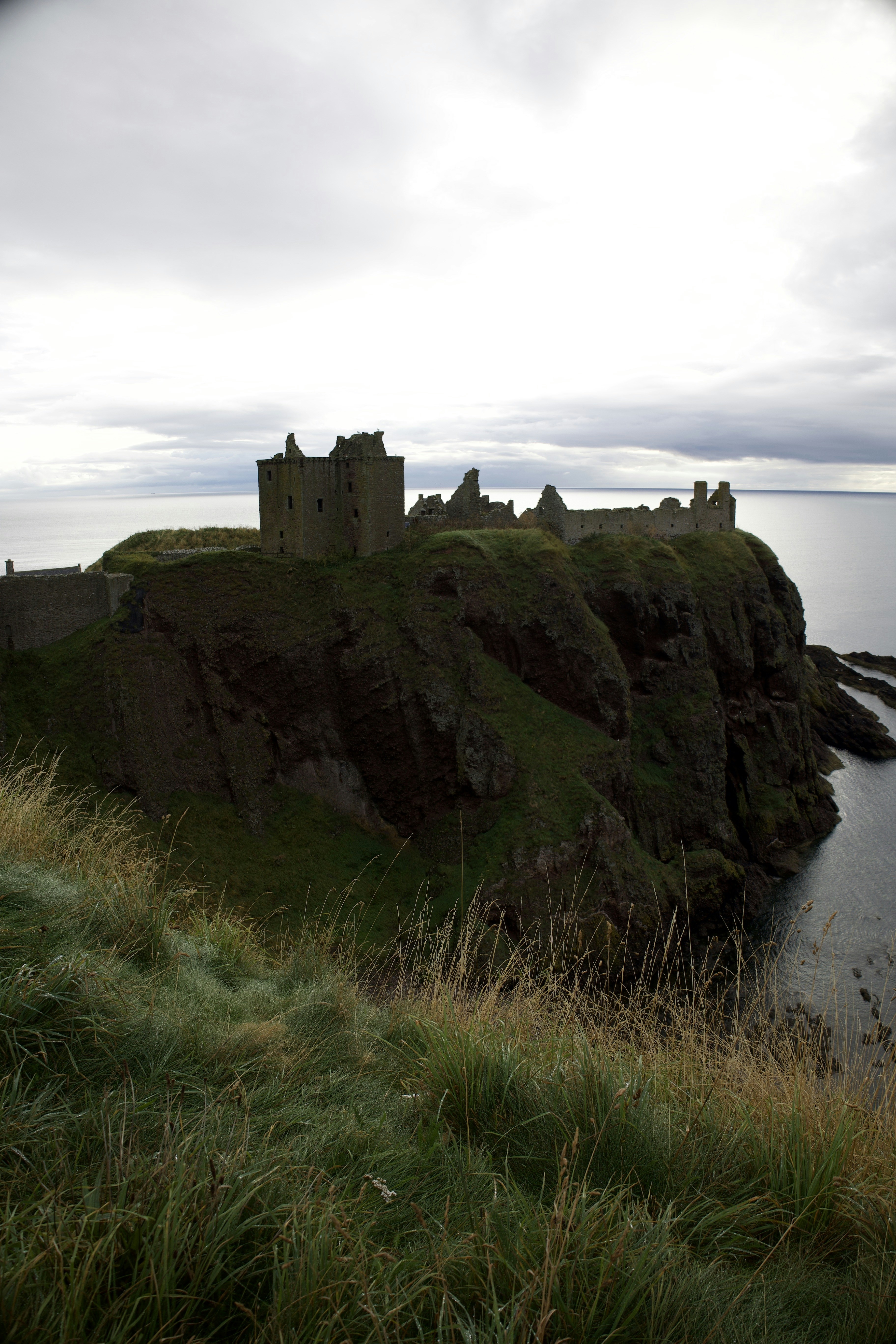 a castle sitting on top of a cliff next to a body of water