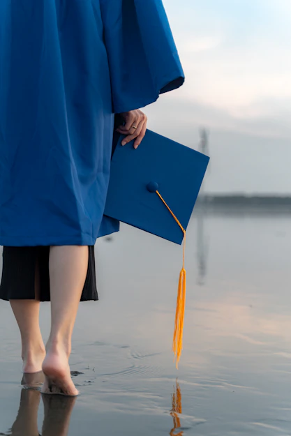 a person in a blue graduation gown holding a book
