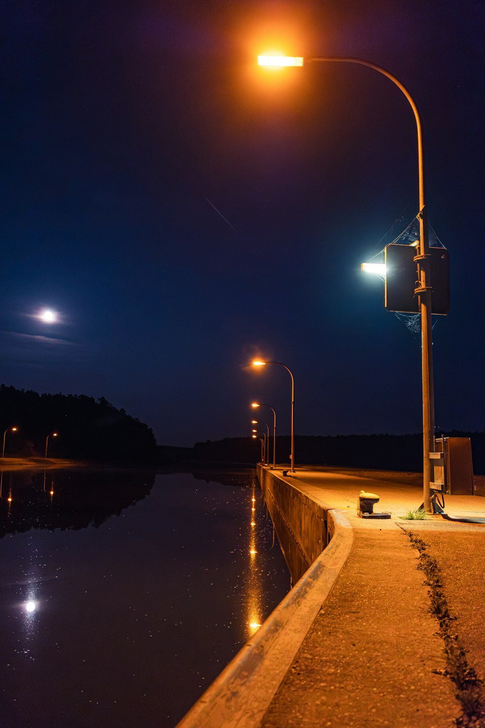 un lampione vicino a uno specchio d'acqua di notte