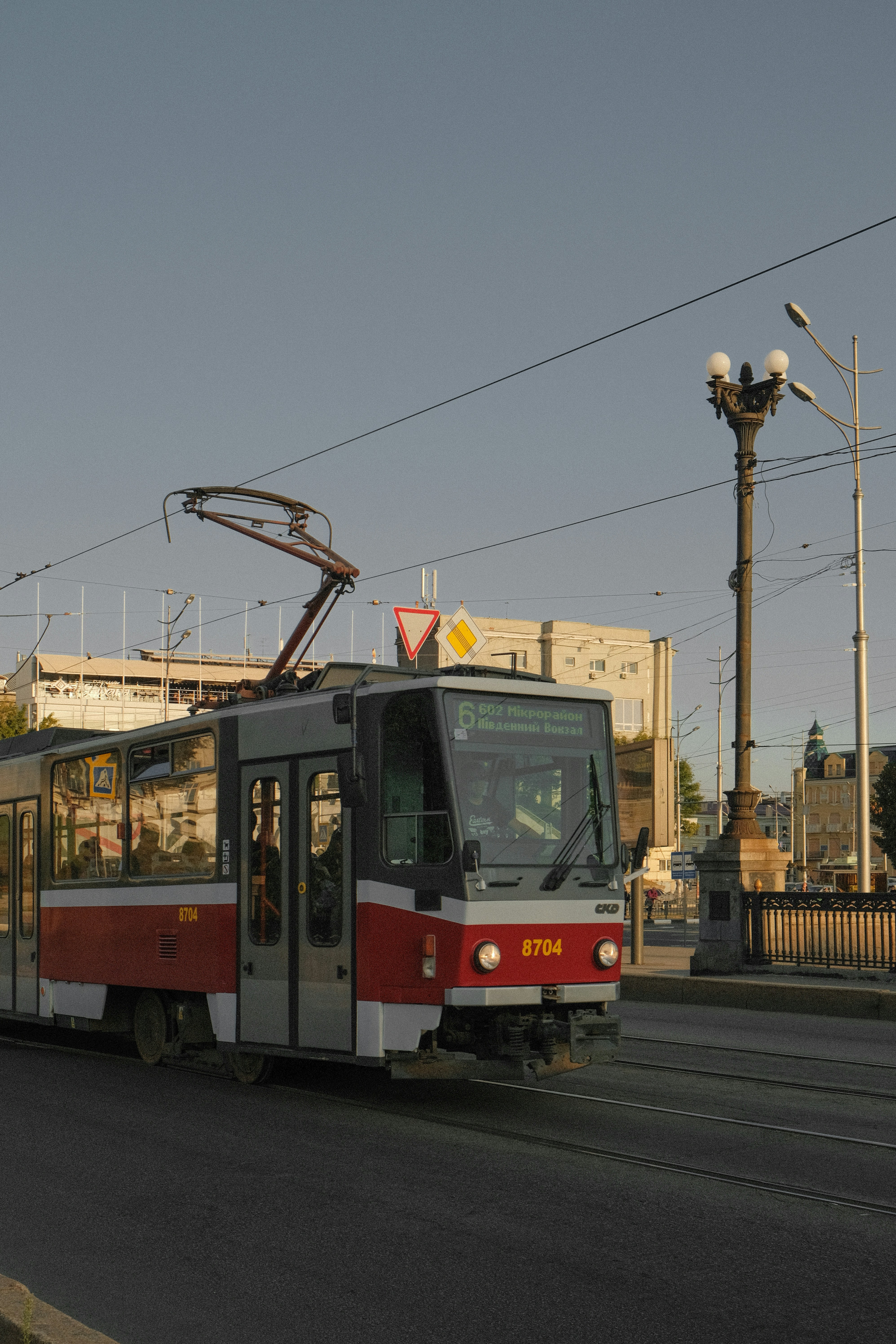 a red and white train traveling down a street