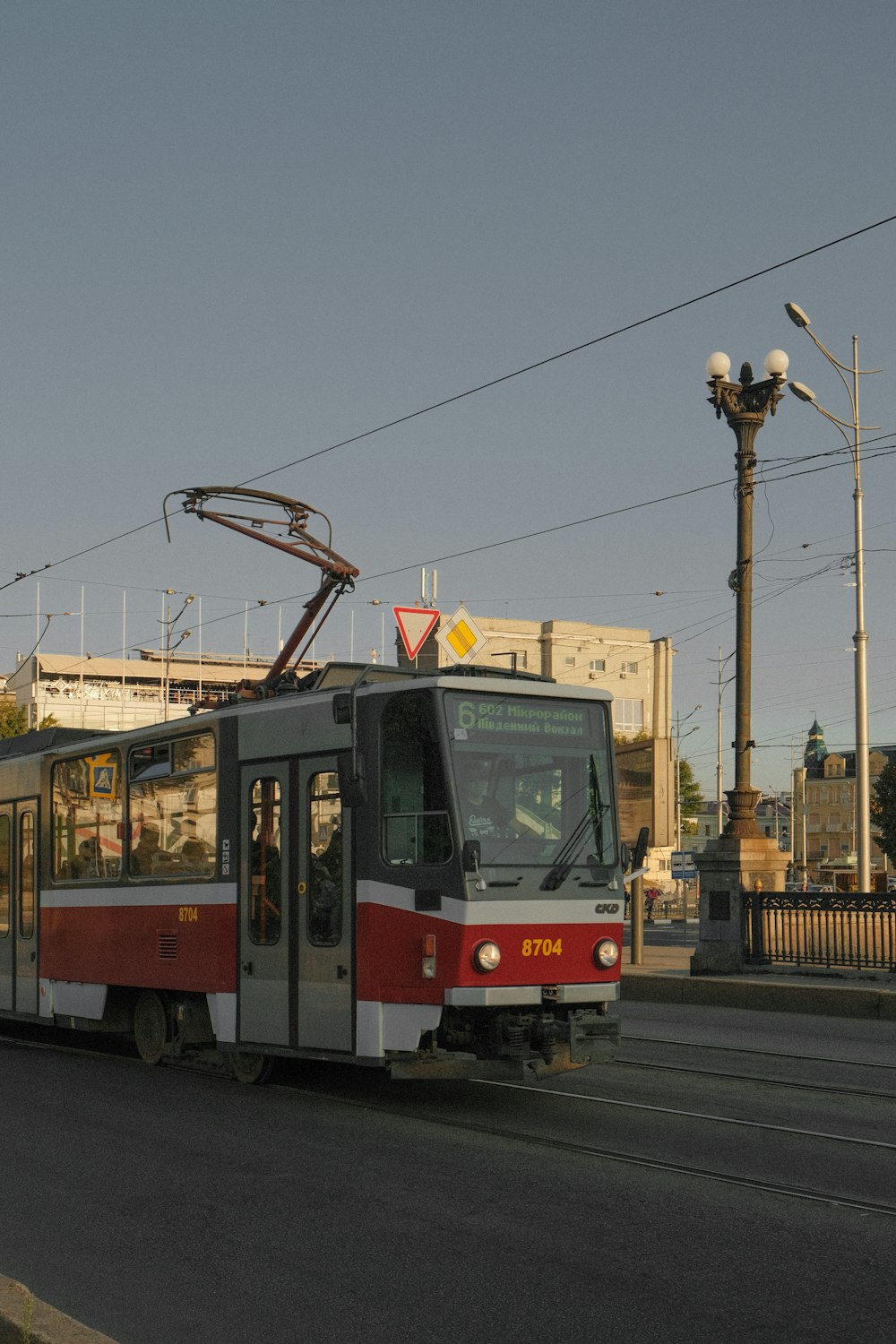 a red and white train traveling down a street