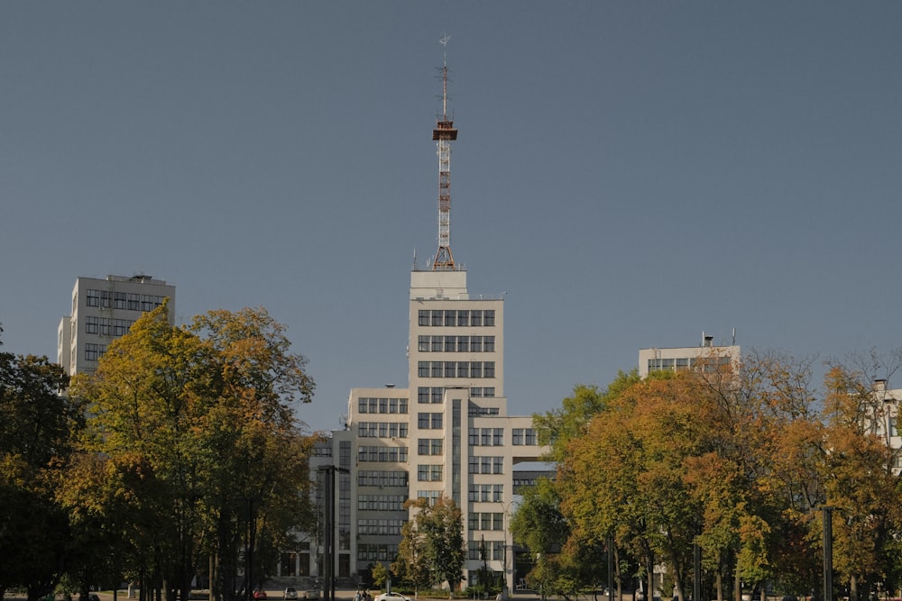 a tall white building with a radio tower on top of it