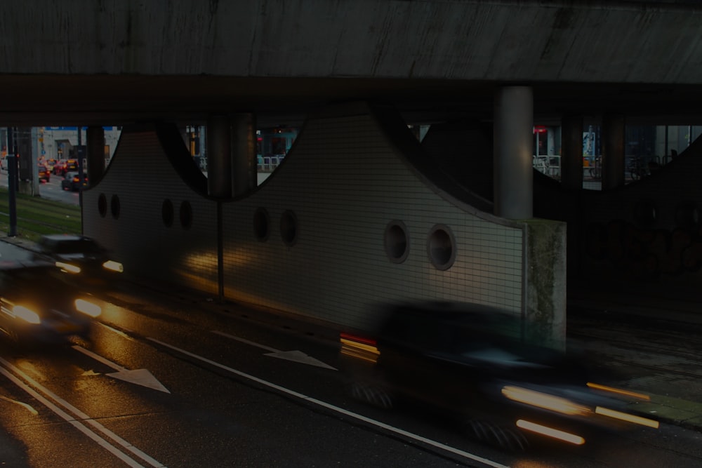 a car driving under a bridge at night