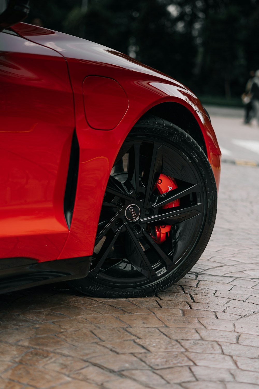 a red sports car parked on a cobblestone street