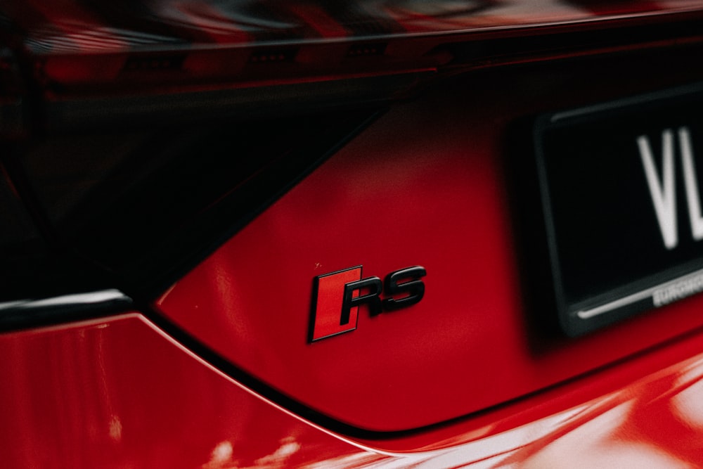 um close up do emblema em um carro esportivo vermelho