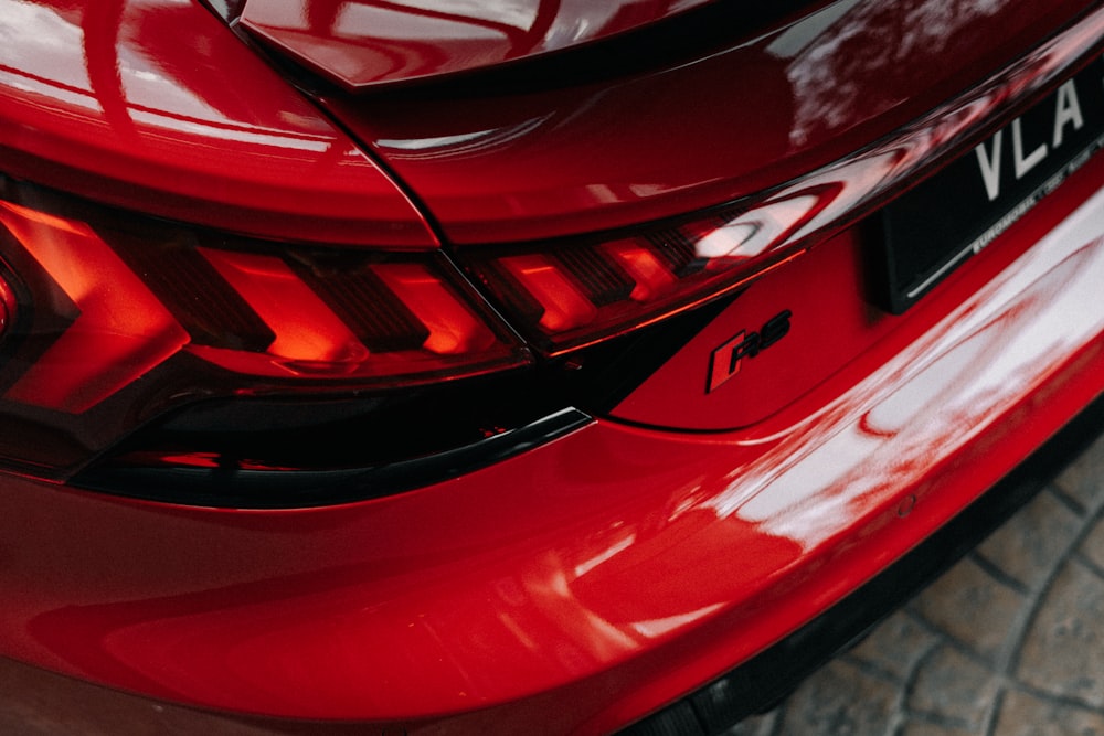 a close up of the tail lights of a red car
