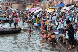 Colorful street scene in Varanasi with pilgrims performing rituals along the Ganges River.