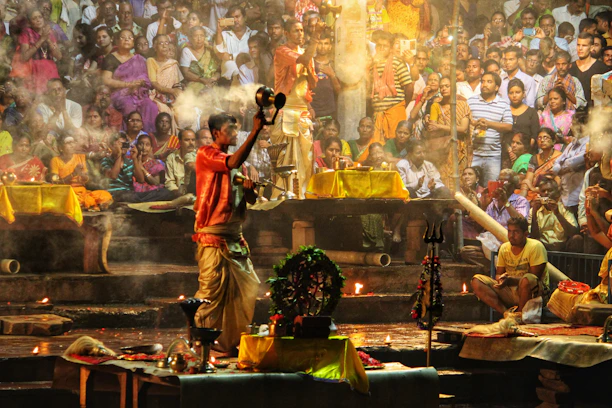 A vibrant scene of priests performing Ganga aarti with glowing diyas against a twilight sky.