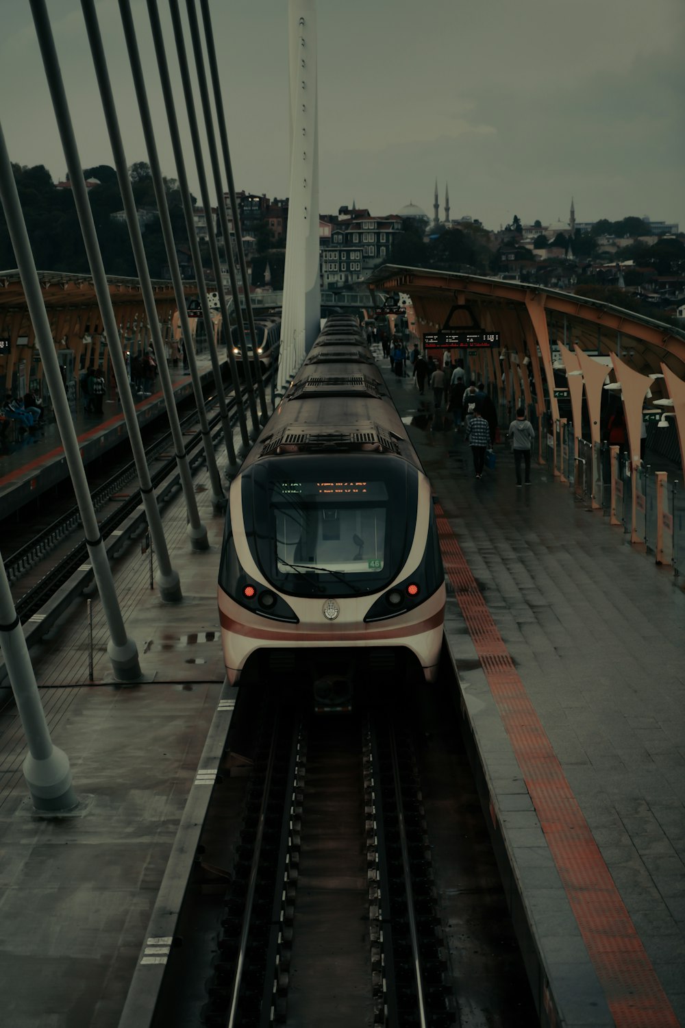 um trem viajando pelos trilhos do trem ao lado de uma estação