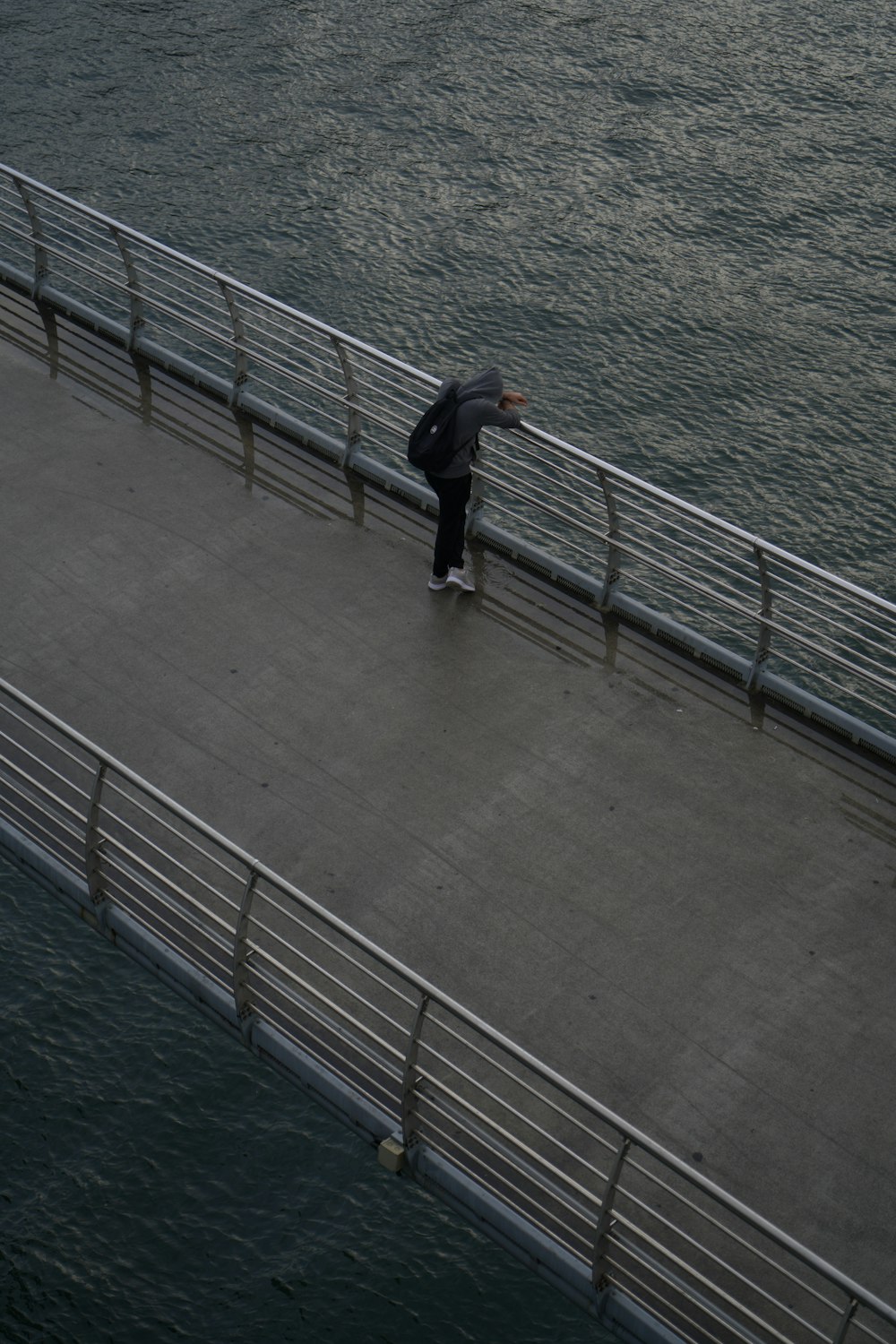 Un hombre está patinando en un puente sobre el agua