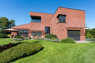a large brick house with a green lawn in front of it