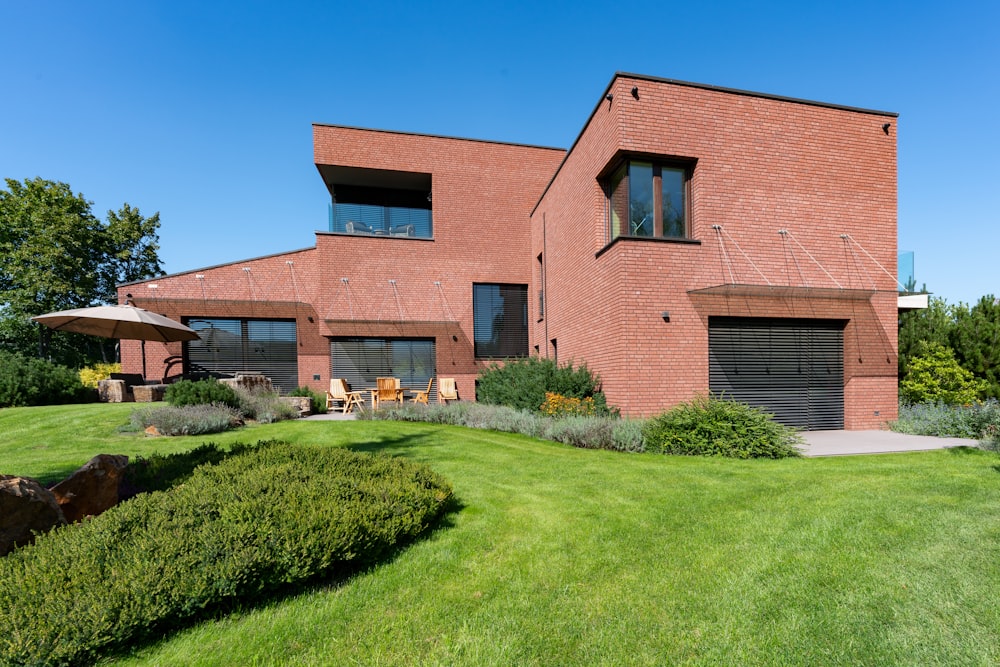 a large brick house with a green lawn in front of it