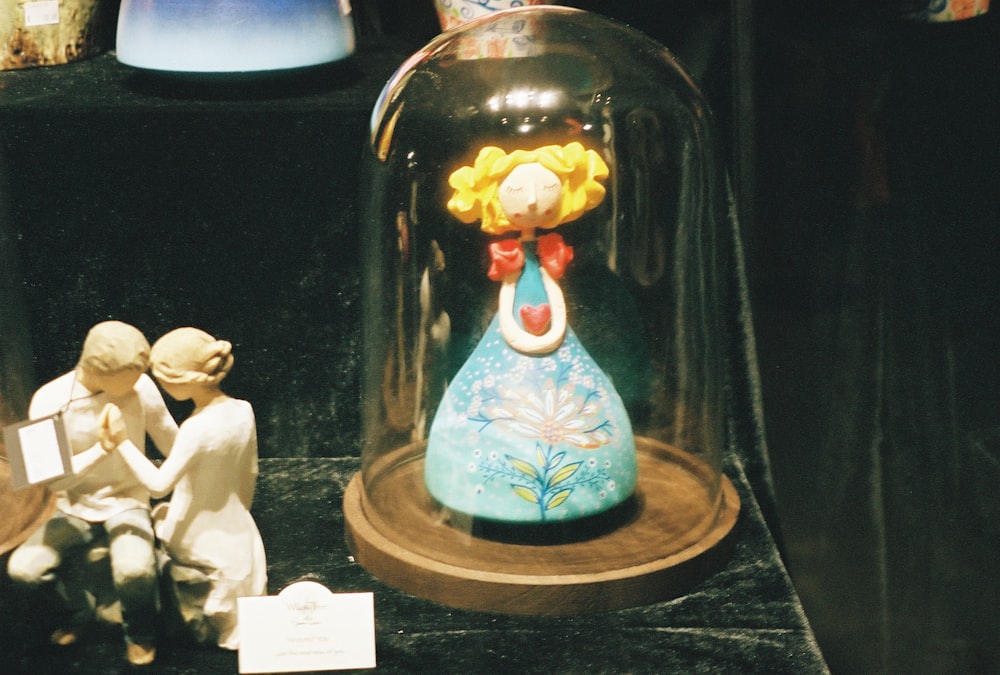 a couple of figurines under a glass dome