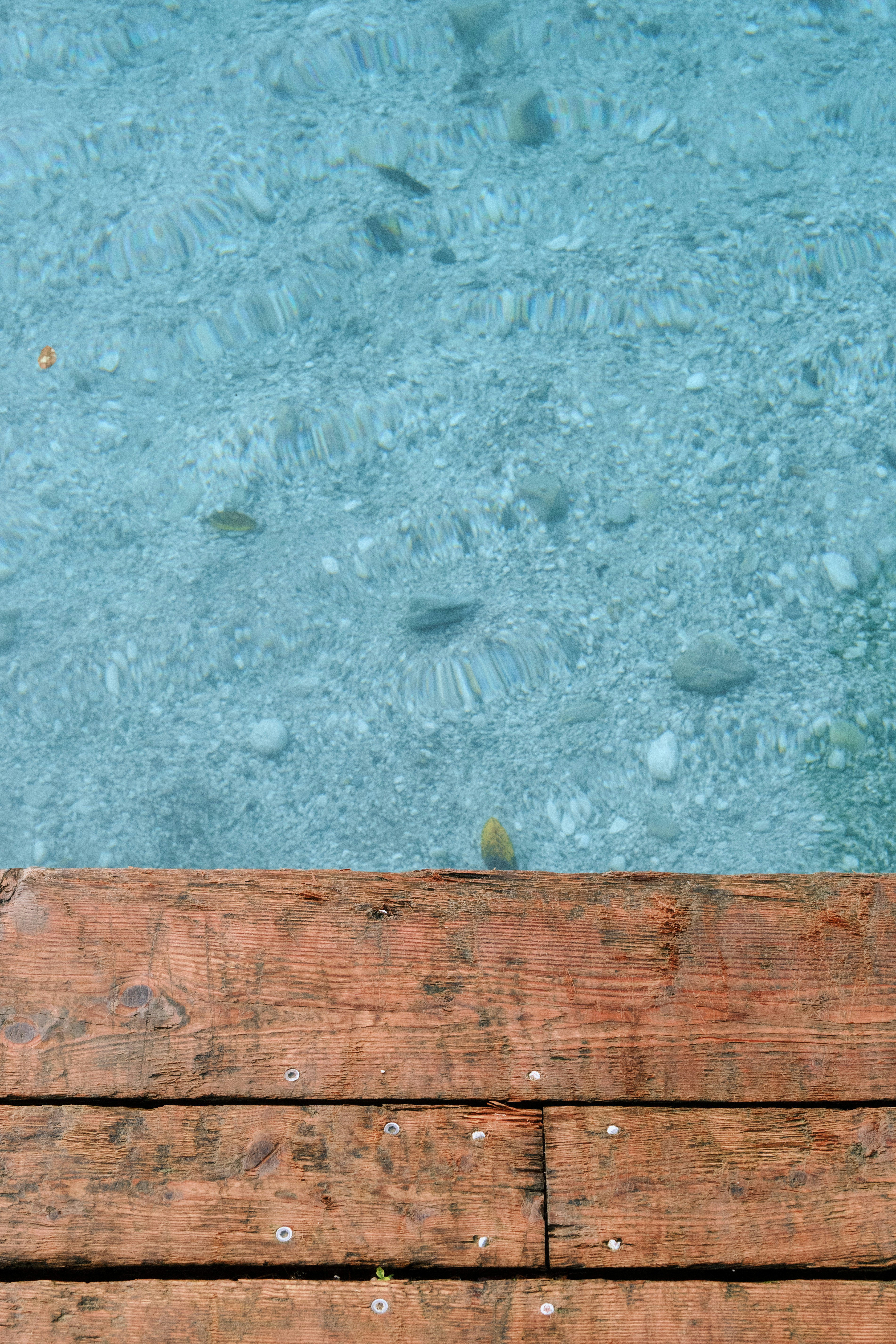 A wooden bench sitting next to a body of water photo – Free Wood Image ...